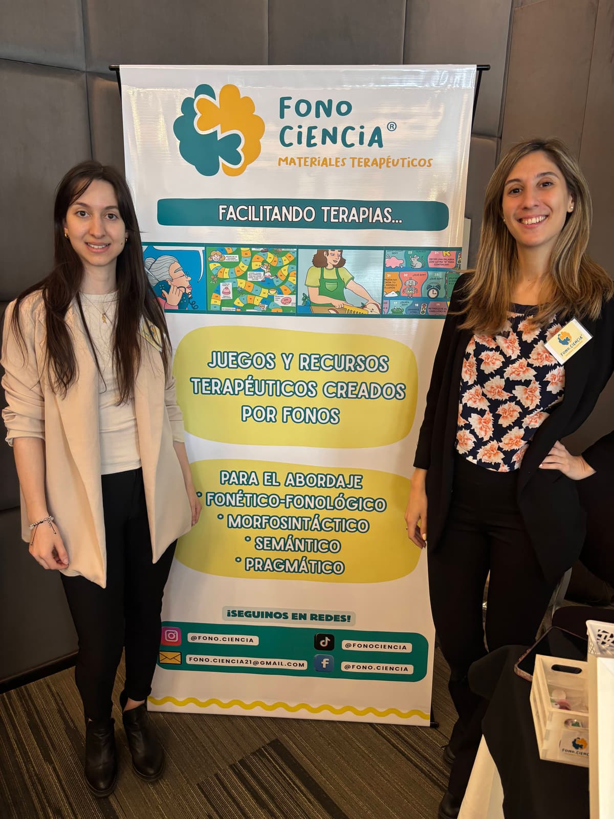 Agustina y Débora junto al banner de Fono.Ciencia